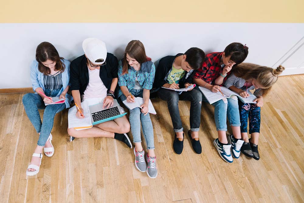 grupo-adolescentes-sentados-suelo-estudiando